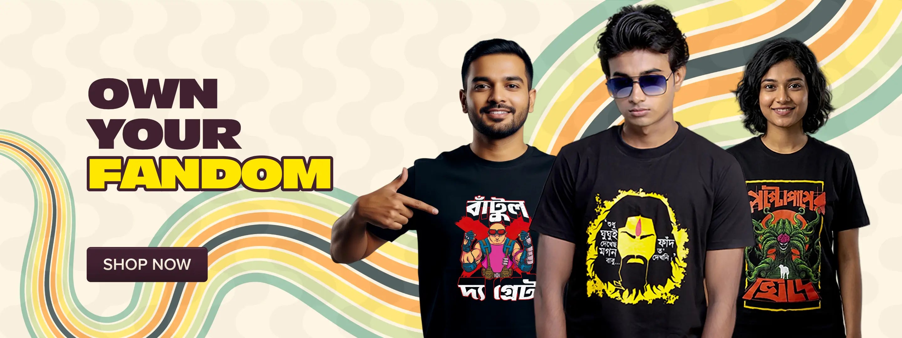 Three men wearing graphic t-shirts stand against a retro wavy multicolor background with the text 'OWN YOUR FANDOM' and a 'SHOP NOW' button. The shirts feature bold Bengali text and graphic prints in yellow, red, green, and black.